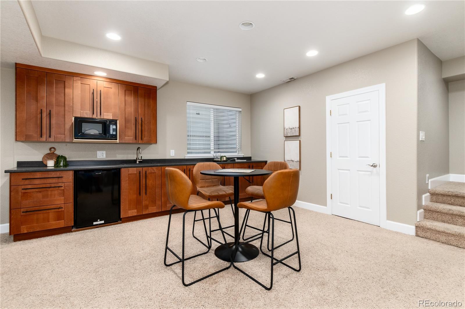 3064 Rams Horn Run Broomfield, CO 80023 - Photo 33 of 47 a kitchen with stainless steel appliances kitchen island granite countertop a stove a sink a refrigerator with a dining table and chairs