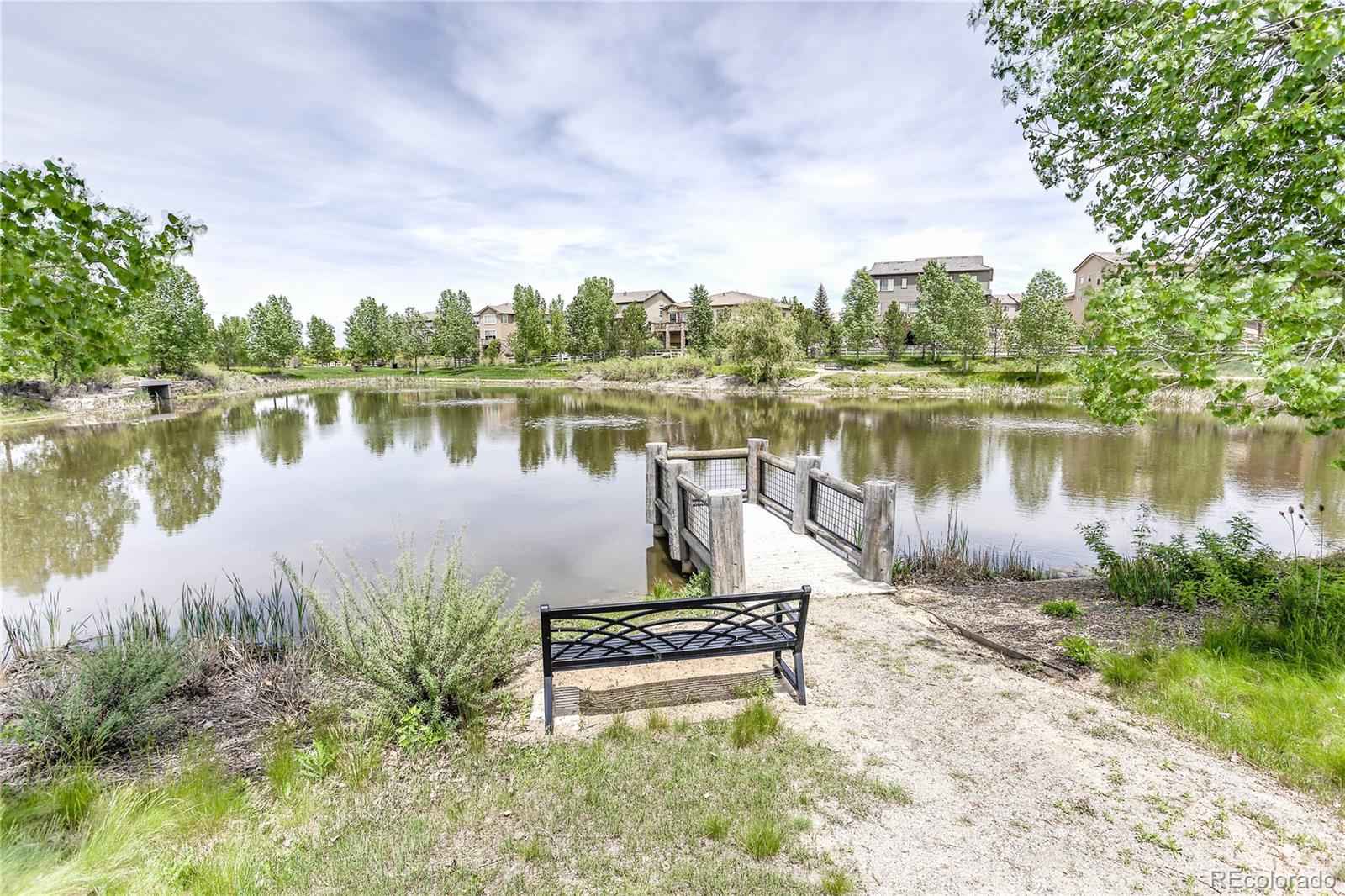 3064 Rams Horn Run Broomfield, CO 80023 - Photo 46 of 47 a lake view with a bench and trees around