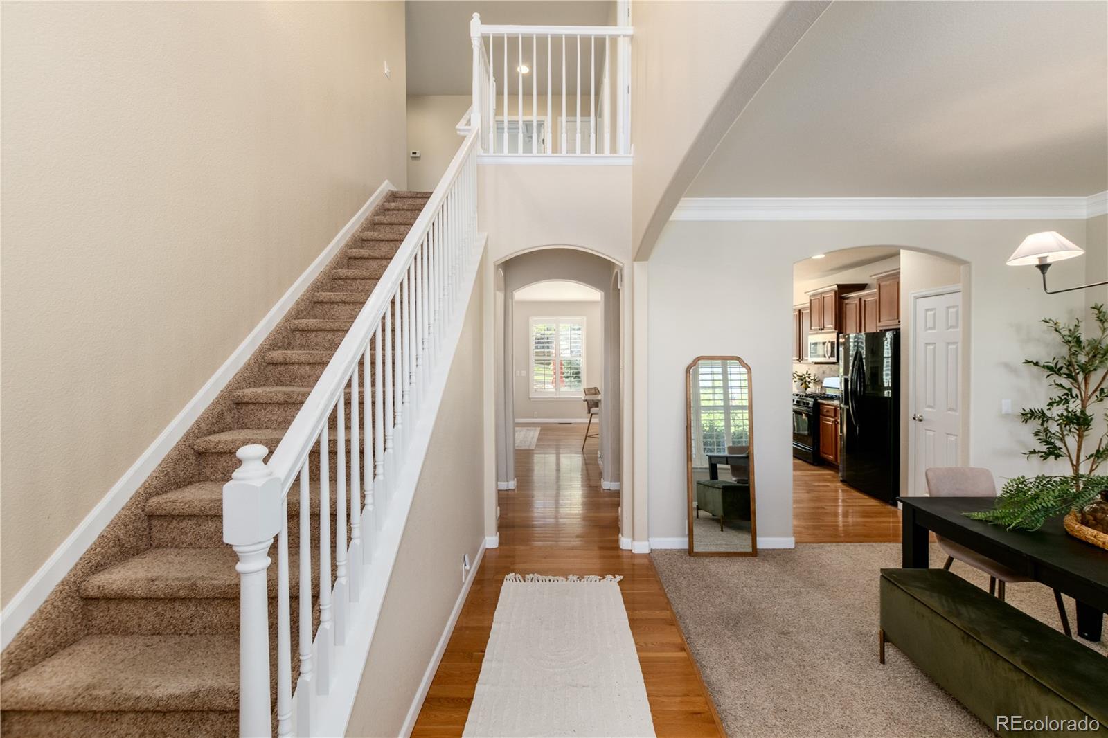 3064 Rams Horn Run Broomfield, CO 80023 - Photo 6 of 47 a view of a hallway to a livingroom with wooden floor and furniture