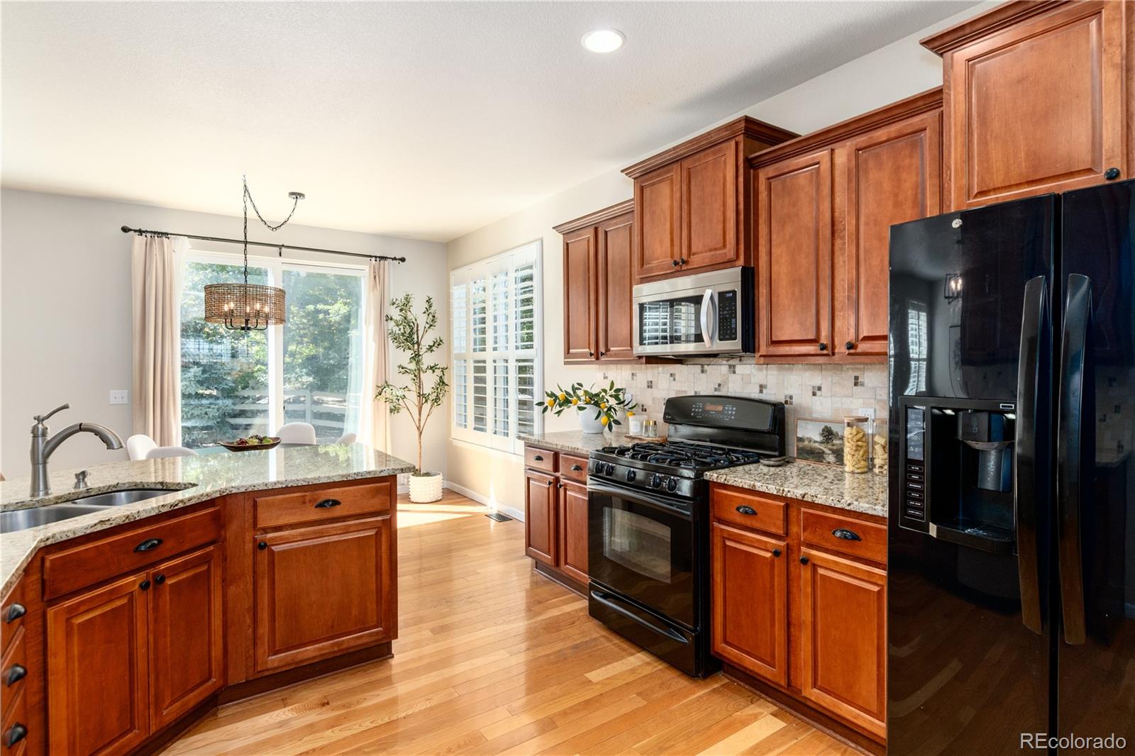3064 Rams Horn Run Broomfield, CO 80023 - Photo 10 of 47 a kitchen with stainless steel appliances granite countertop a stove a sink dishwasher a refrigerator and a microwave oven