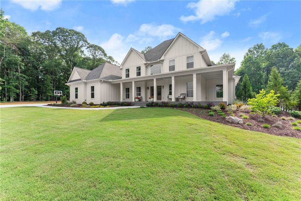 6998 Britt Gailey Road Clermont, GA 30527 - Photo 75 of 92 a front view of a house with a garden and trees