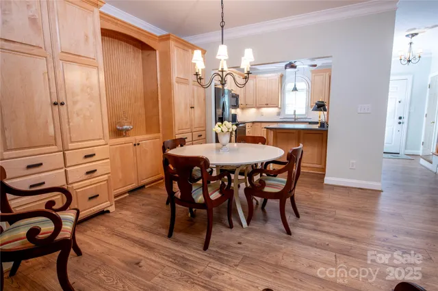 a view of a a dining room and livingroom with furniture wooden floor a chandelier