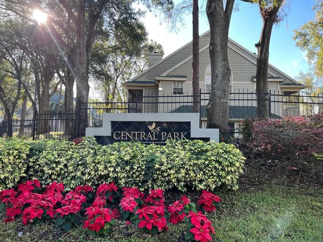 a front view of a house with a yard and fountain in middle of the house