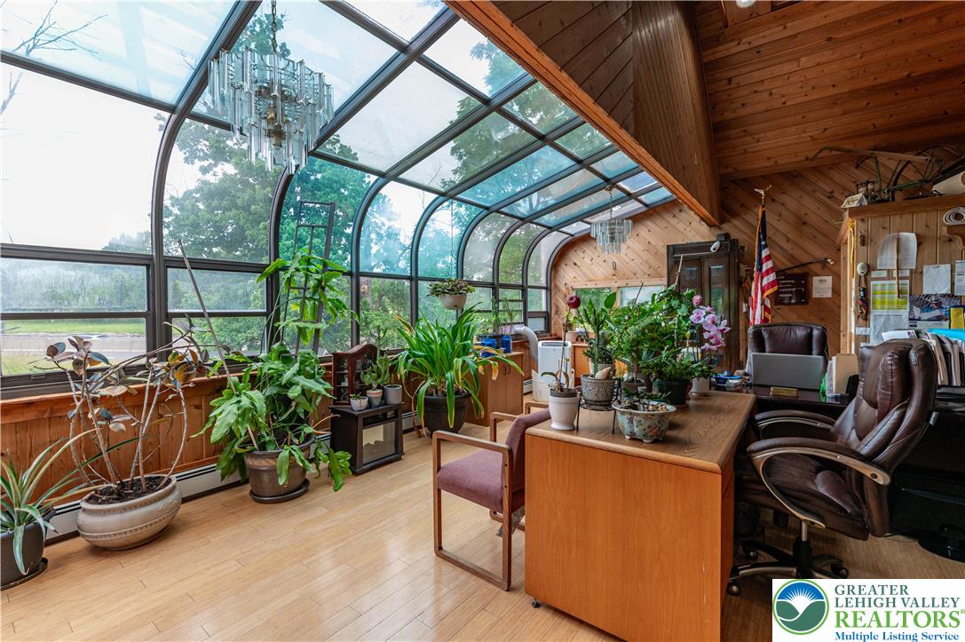 2485 Hieter Road Quakertown, PA 18951 - Photo 40 of 97 A glass-enclosed sunroom with wood plank walls and a hardwood floor offers a bright, versatile living space.