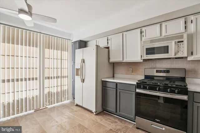 a kitchen with stainless steel appliances white cabinets and a stove top oven