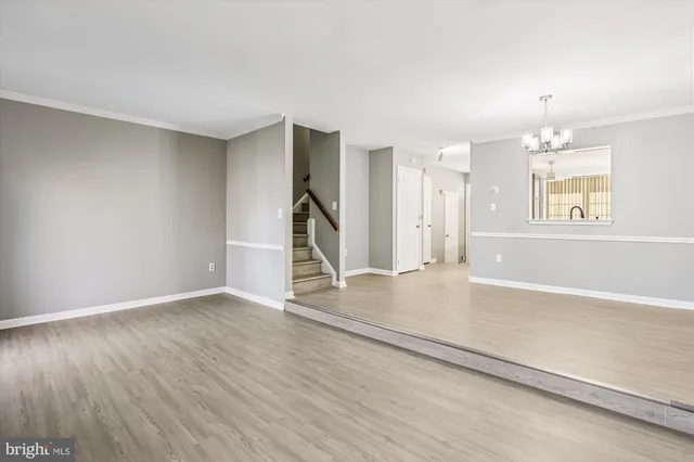 an empty room with wooden floor and window