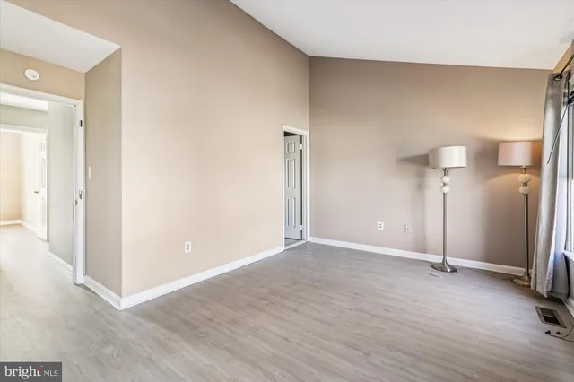 an empty room with wooden floor and a bathroom
