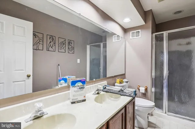 a bathroom with a sink vanity granite and toilet