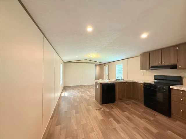 a large white kitchen with wooden floor
