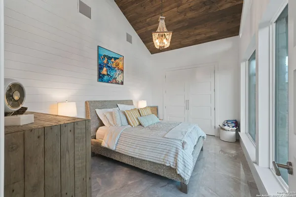 a bedroom with a bed and a chandelier