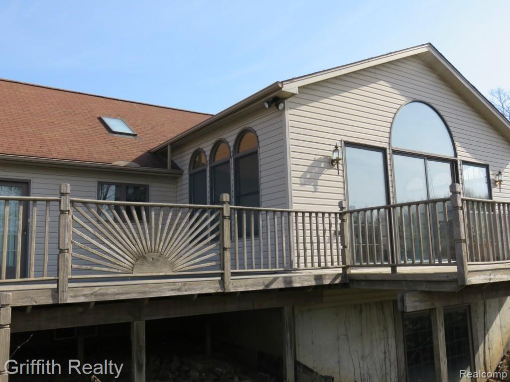 20563 Wasson Road Pinckney, MI 48169 - Photo 6 of 44 Rear of the home depicting the decking, arc windows in FmRm, skylite in kitchen, walkout LL.