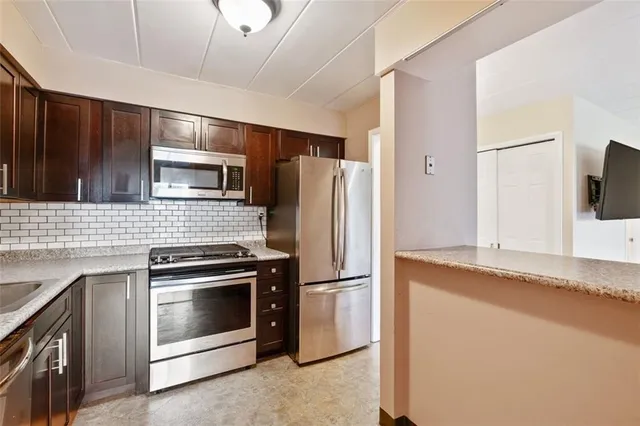 a kitchen with granite countertop a refrigerator and a sink