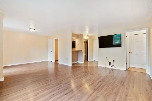 a view of a livingroom with wooden floor and a flat screen tv
