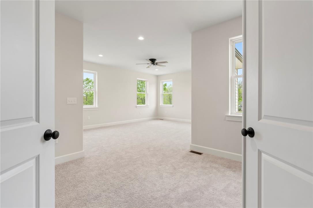 Hottle Road Quakertown, PA 18951 - Photo 27 of 59 Double doors open to a spacious, carpeted bedroom with multiple windows looking out to trees.