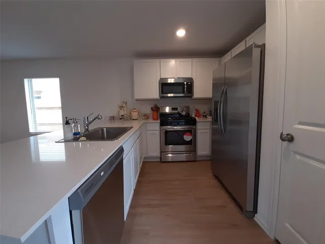 a kitchen with stainless steel appliances granite countertop a refrigerator a sink a stove a microwave and island