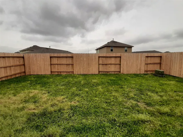a view of a backyard with potted plants and wooden fence