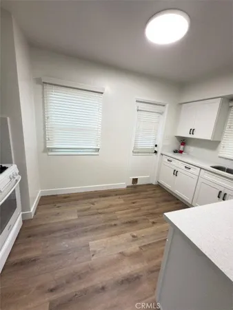 a view of a kitchen with wooden floor and electronic appliances