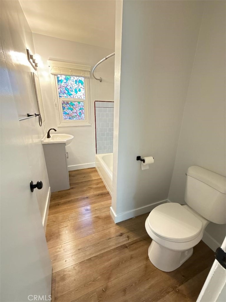 7457 Mt Vernon Street, Unit A Riverside, CA 92504 - Photo 4 of 7 a white toilet sitting next to a bathroom sink and a mirror