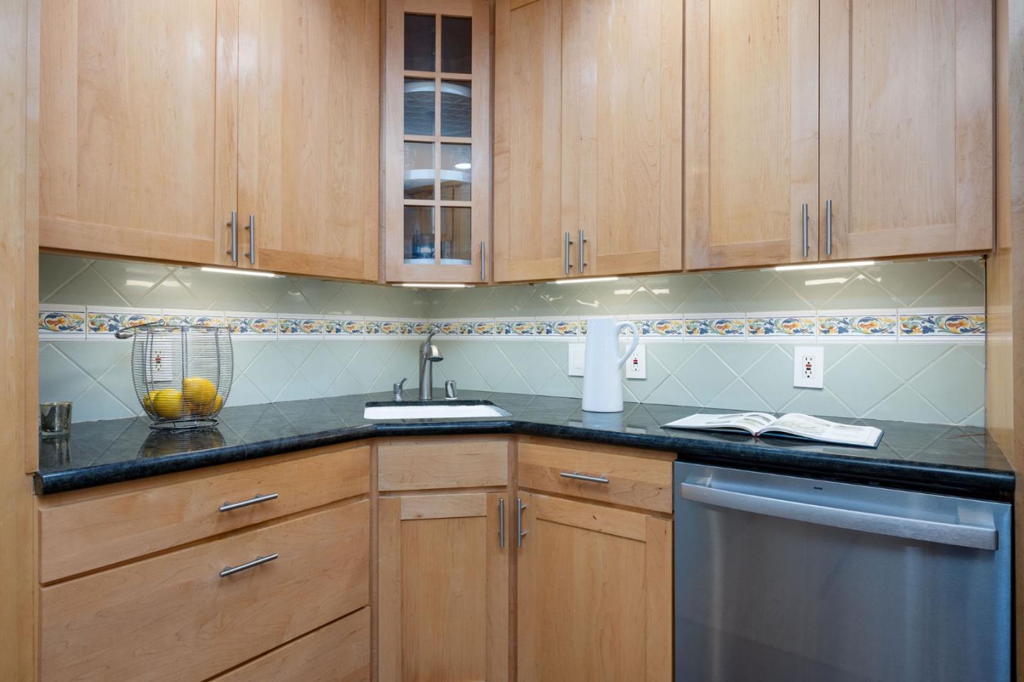 1572 Linda Mar Boulevard Pacifica, CA 94044 - Photo 12 of 25 a kitchen with stainless steel appliances granite countertop white cabinets sink and dishwasher