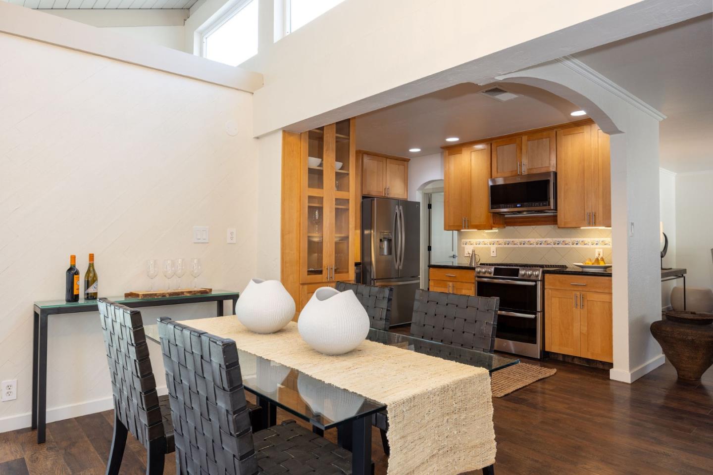 1572 Linda Mar Boulevard Pacifica, CA 94044 - Photo 9 of 25 a kitchen with granite countertop a table chairs microwave and cabinets