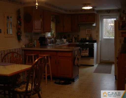 1 John Place Helmetta, NJ 08828 - Photo 2 of 8 a kitchen with a table chairs sink and cabinets