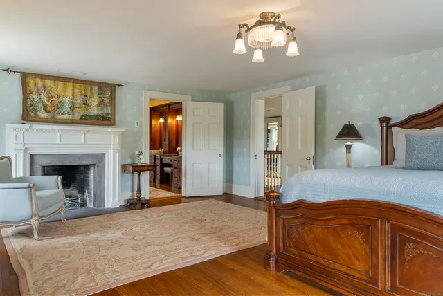 a spacious bedroom with a bed and a fireplace