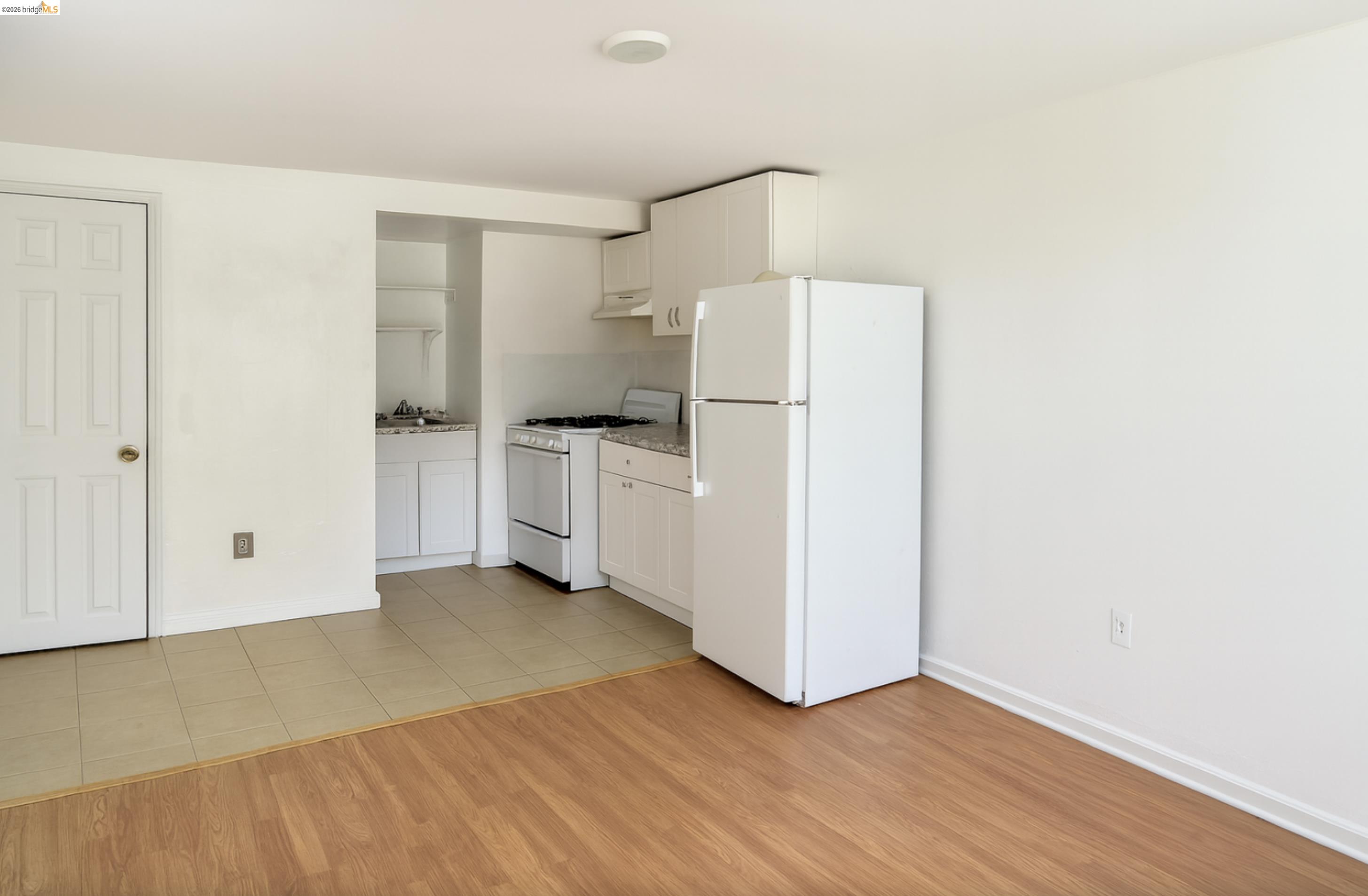 121 Lincoln Road East Vallejo, CA 94590 - Photo 9 of 15 Kitchen with white appliances, white cabinets, light countertops, and light wood finished floors
