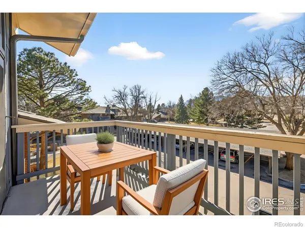 a view of a balcony with wooden floor and outdoor seating