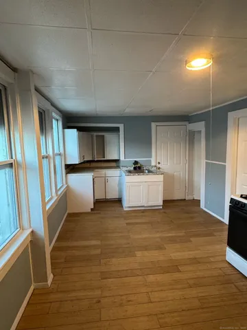 a view of a kitchen with wooden floor and electronic appliances