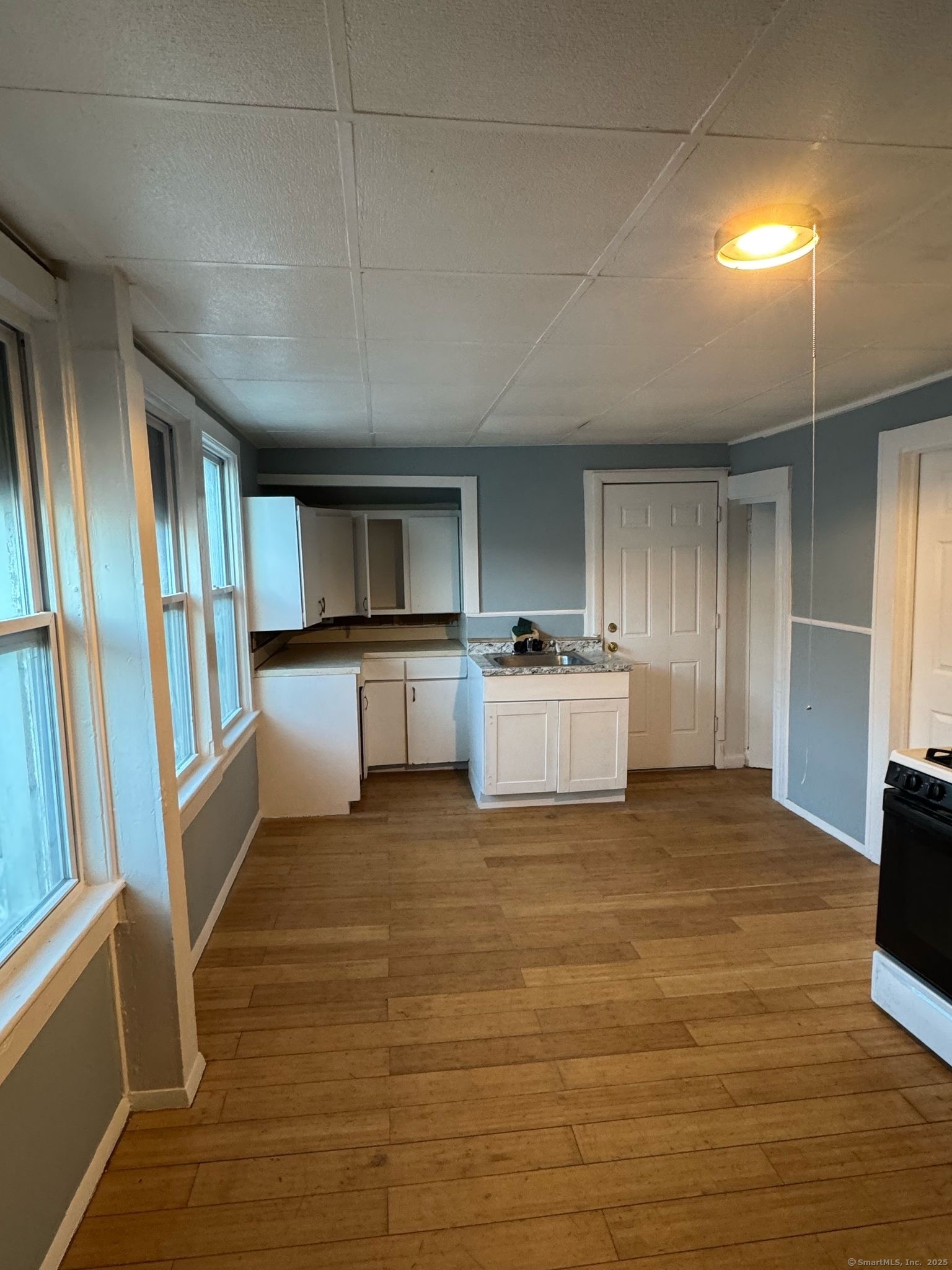 a view of a kitchen with wooden floor and electronic appliances
