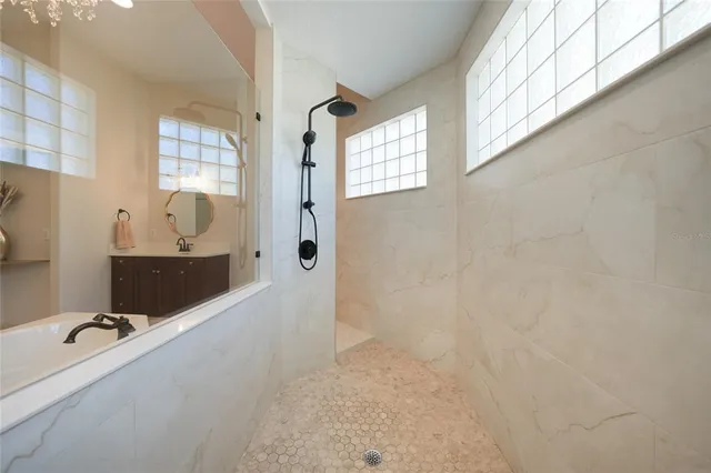 a bathroom with a tub sink and mirror