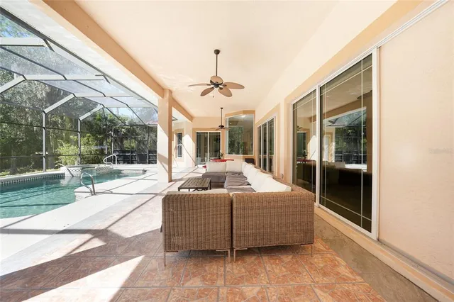 a living room with couches a flat screen tv and a floor to ceiling window