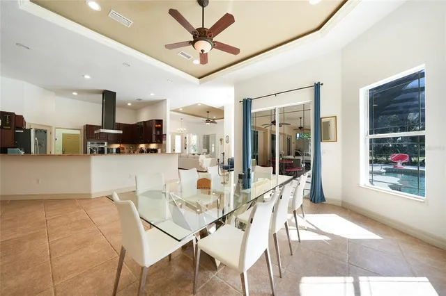 a dining room with stainless steel appliances kitchen island granite countertop a table chairs and a view of kitchen