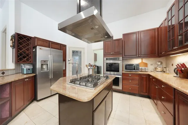 a kitchen with stainless steel appliances kitchen island granite countertop a sink stove and refrigerator