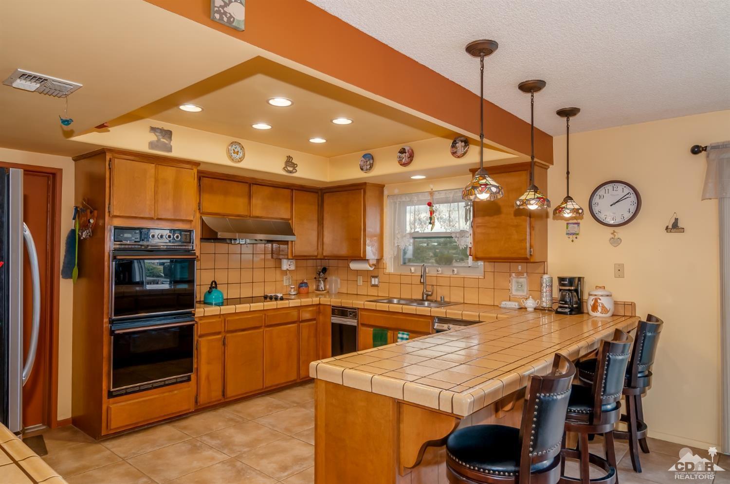 3290 Julcrest Road Yucca Valley, CA 92284 - Photo 7 of 20 a kitchen with stainless steel appliances granite countertop a sink a stove and a refrigerator