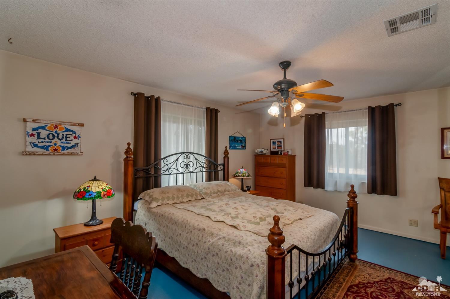 3290 Julcrest Road Yucca Valley, CA 92284 - Photo 8 of 20 a bedroom with a bed and a chandelier