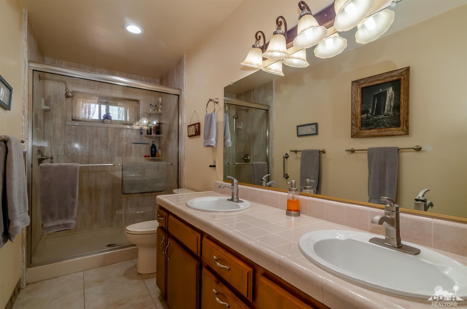3290 Julcrest Road Yucca Valley, CA 92284 - Photo 10 of 20 a bathroom with a double vanity sink mirror and shower