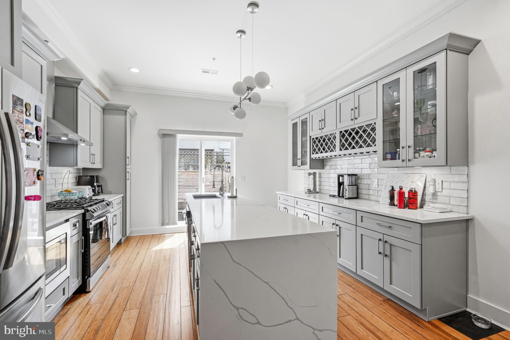 2604 Reed Street Philadelphia, PA 19146 - Photo 6 of 45 a kitchen with stainless steel appliances granite countertop a stove top oven a sink dishwasher and white cabinets with wooden floor