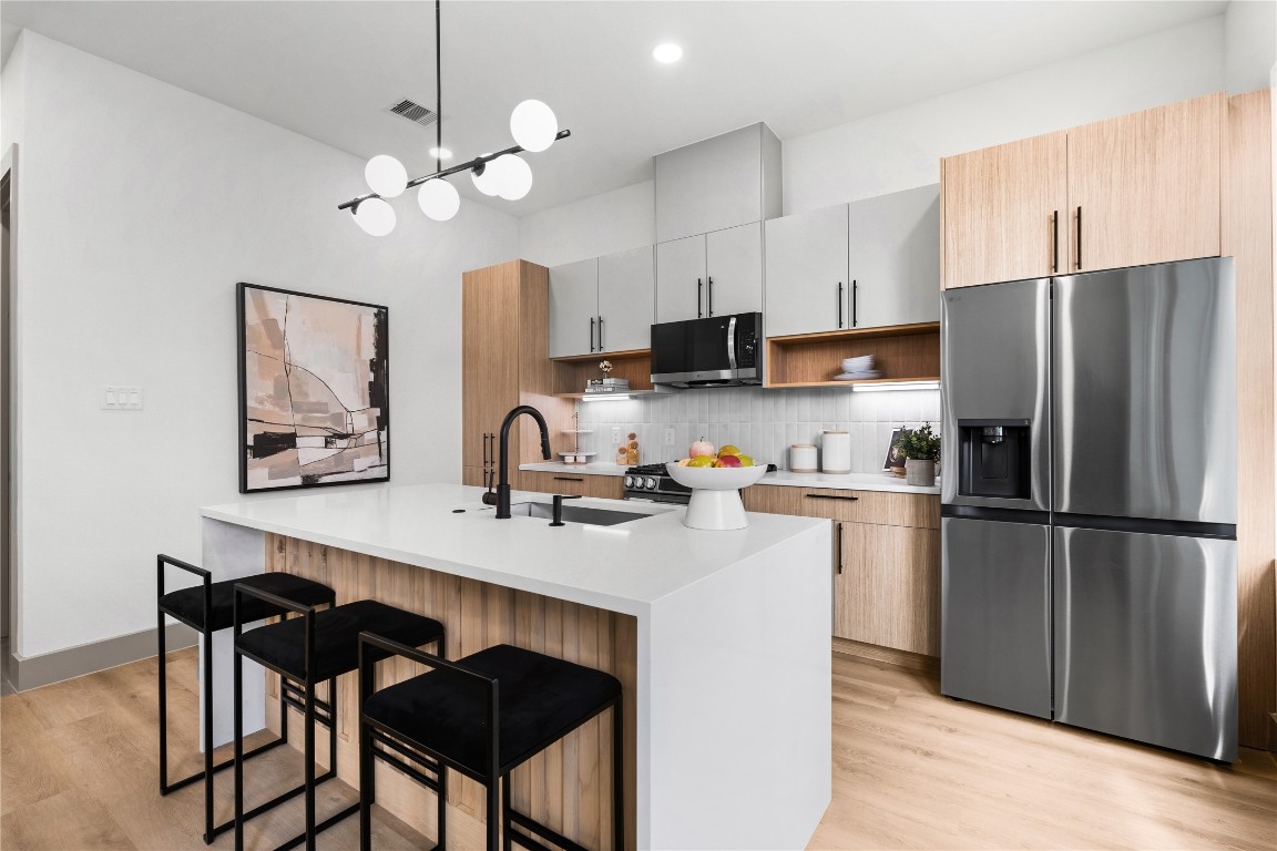 2950 Pitzlin Street Houston, TX 77023 - Photo 11 of 37 This statement island does it all—prep, serve, sip your morning coffee or gather with friends. Wrapped in a waterfall quartz slab with slatted wood detail and matte black fixtures, it's where everyday routines feel a little more luxurious.