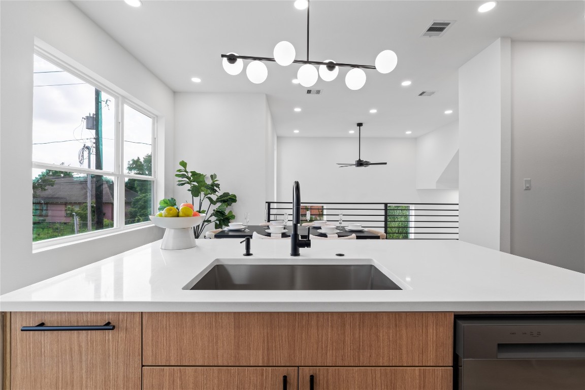 2950 Pitzlin Street Houston, TX 77023 - Photo 15 of 37 Wake up to sunlight pouring through oversized windows as you prep at this striking island—complete with a matte black faucet, deep undermount sink, and seamless quartz countertops. Designed for daily life and entertaining alike, it’s the perfect perch for morning coffee, casual conversations, or catching golden hour.