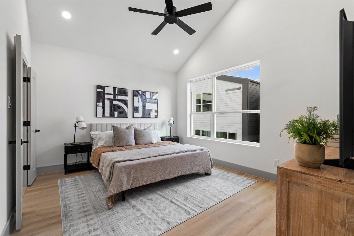 2950 Pitzlin Street Houston, TX 77023 - Photo 20 of 37 A peaceful primary retreat awaits—anchored by vaulted ceilings, wide-plank SPC flooring, and oversized windows that fill the space with natural light. The clean, modern aesthetic offers a calming backdrop for rest, recharge, and everyday luxury.