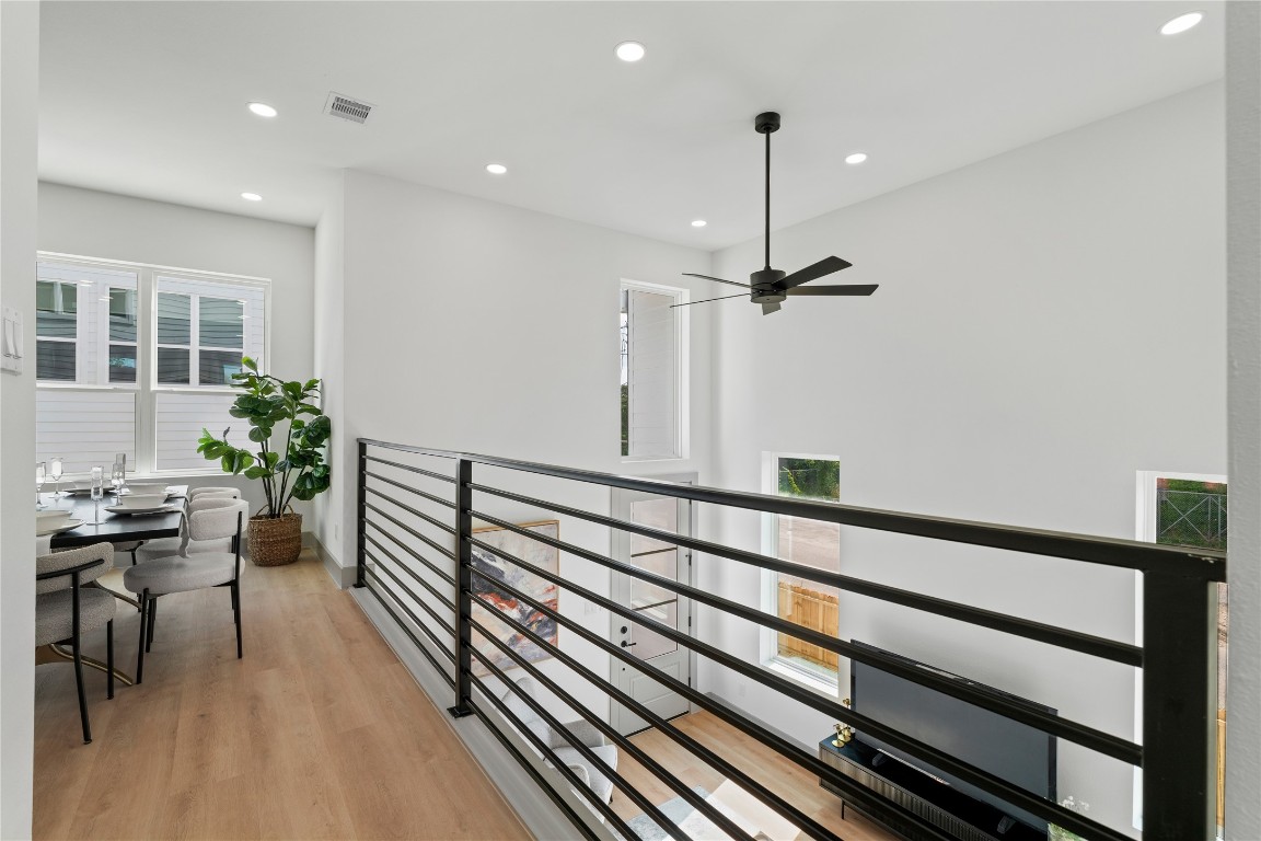 2950 Pitzlin Street Houston, TX 77023 - Photo 6 of 37 Elevated dining with a view—this airy overlook connects seamlessly to the living room below, enhanced by 18-ft ceilings, oversized windows, and sleek modern railings.