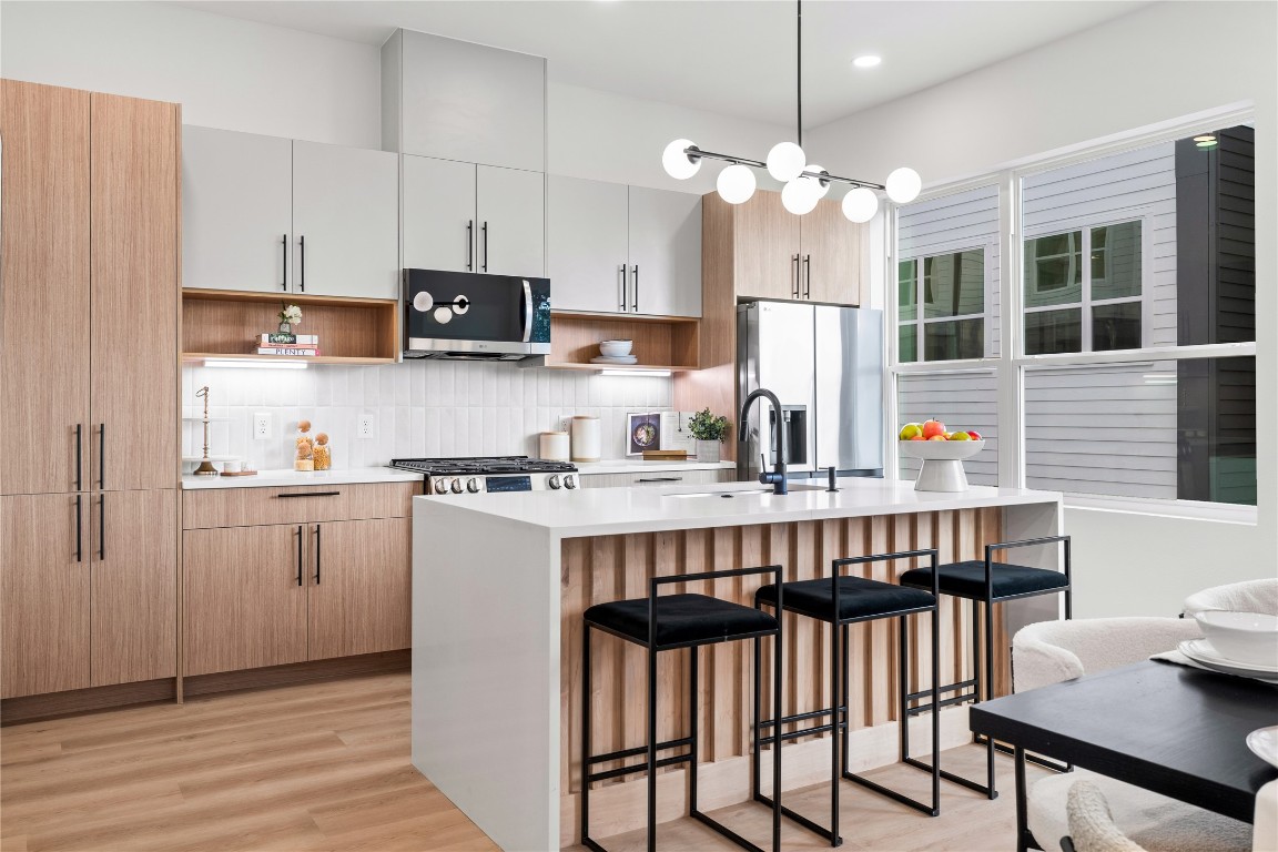 2950 Pitzlin Street Houston, TX 77023 - Photo 9 of 37 A chef-inspired kitchen designed for both beauty and function—quartz countertops, soft-close cabinetry, designer lighting, and a sleek gas range invite you to cook, gather, and make memories in a space that truly feels like home.