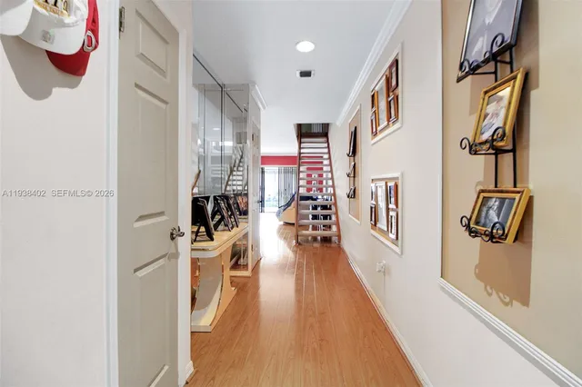 a view of a hallway with wooden floor and stairs