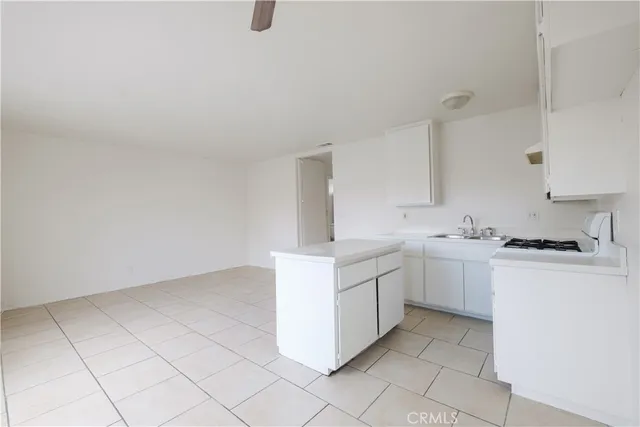 a white kitchen with a sink and cabinets