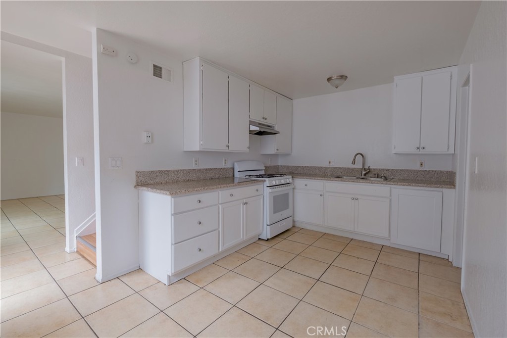 3771 Harvill Lane Riverside, CA 92503 - Photo 13 of 53 a white kitchen with a sink and cabinets