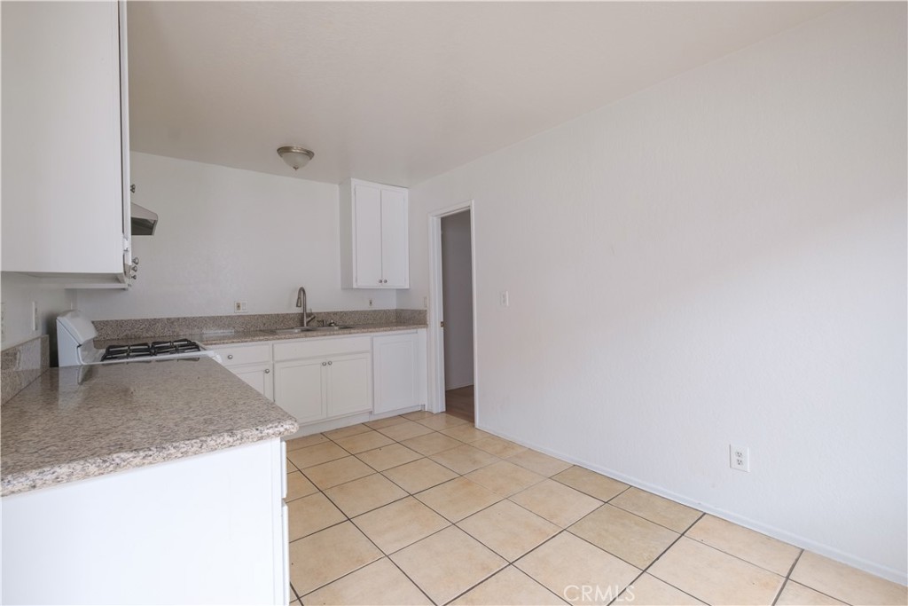 3771 Harvill Lane Riverside, CA 92503 - Photo 25 of 53 a kitchen with granite countertop white cabinets and white appliances