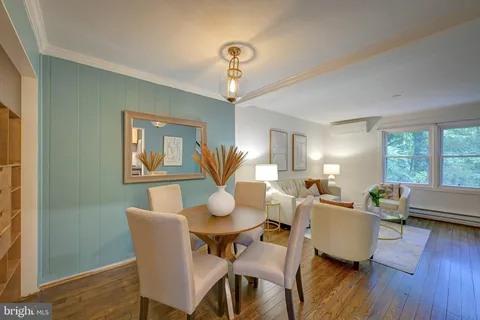 a dining room with wooden floor a chandelier a glass table and chairs