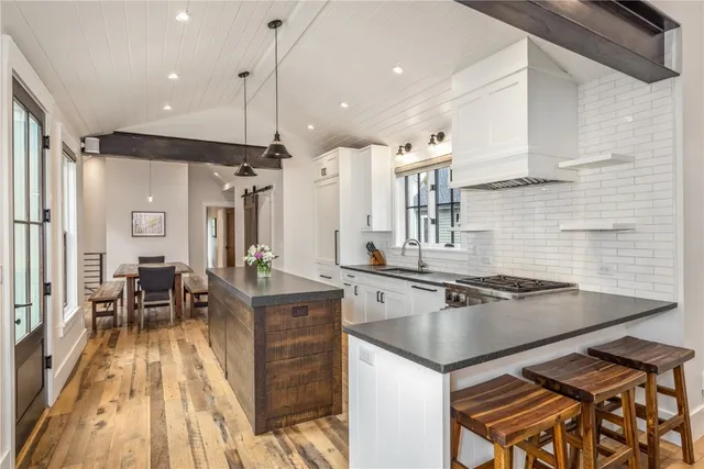 a kitchen with granite countertop a sink appliances and cabinets