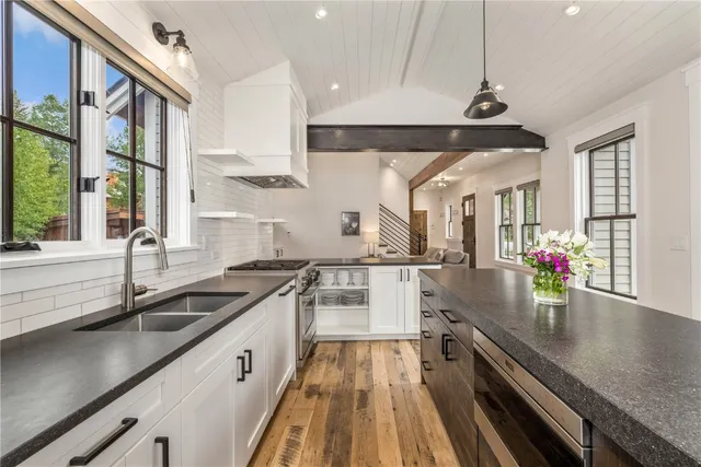 a kitchen with granite countertop a sink a counter space appliances and cabinets